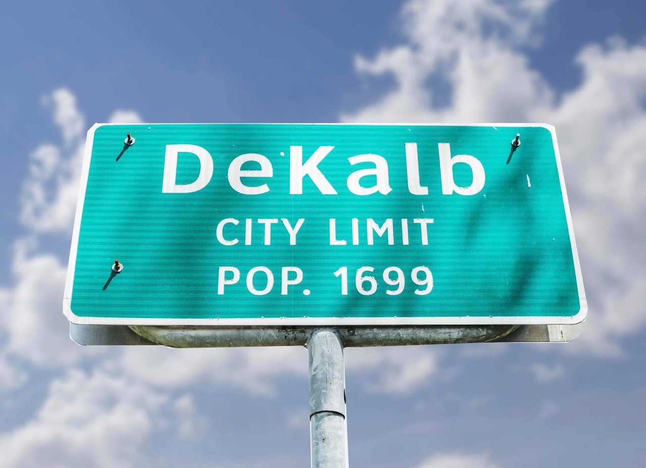 DeKalb city-limit sign showing a population of 1,699.