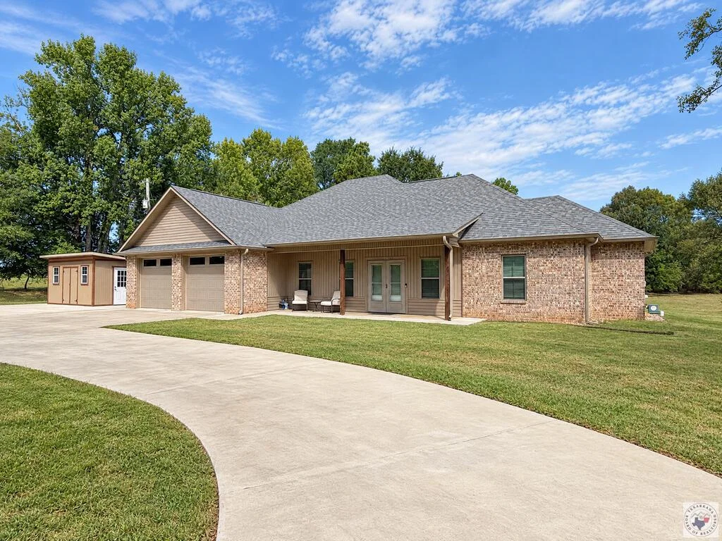 Exterior of 1100 N FM 992 with its circular drive and covered front porch