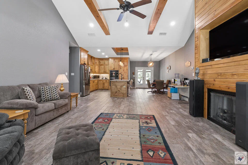 Open living room with timber beams at 1100 N FM 992