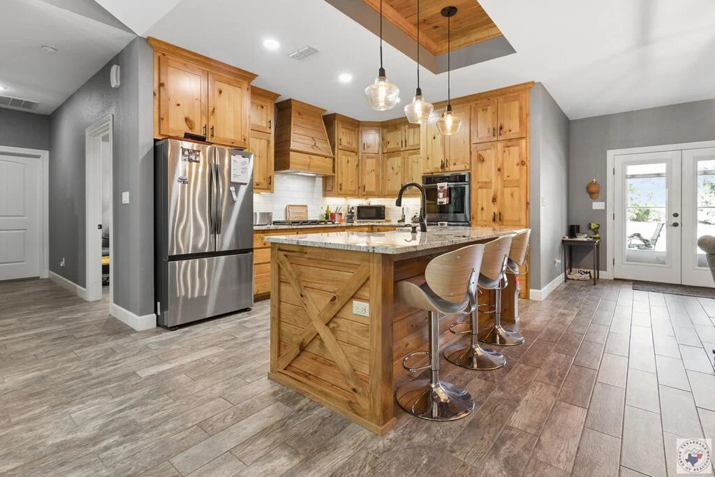 Kitchen island and open living area at 1100 N FM 992