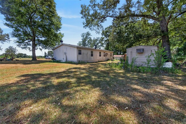 Rear of the home and surrounding yard at 350 County Road 3102